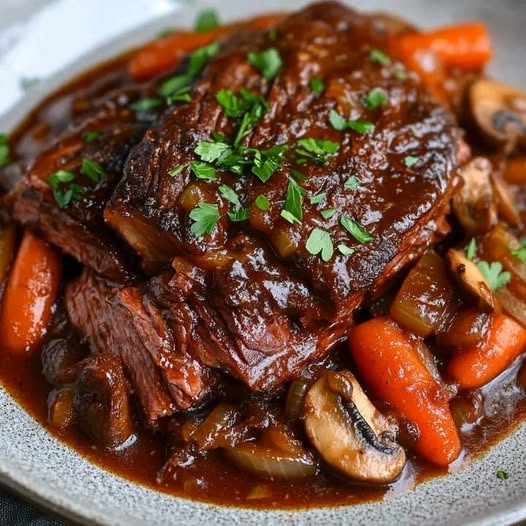 Geschmorte Rinderbrust in einer reichhaltigen roten Sauce mit karamellisierten Zwiebeln, Pilzen und Karotten